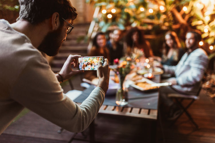 Man photographing friends during party