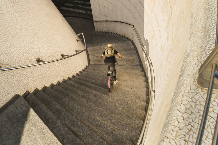 High angle view of man riding bicycle on staircase