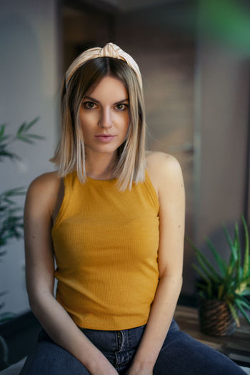 Portrait of beautiful young woman sitting at home