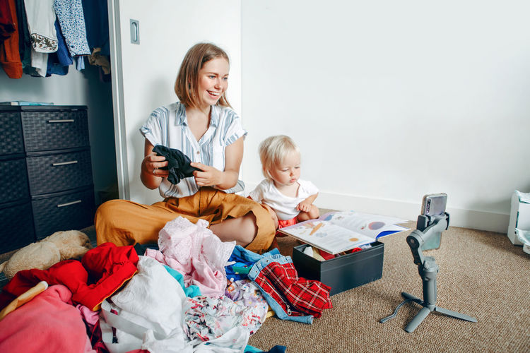 Mother  doing video call chat while sorting clothes at home. woman using gimbal tripod for video 