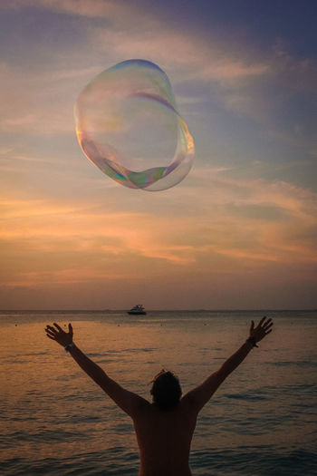Scenic view of bubble in sea against sunset sky