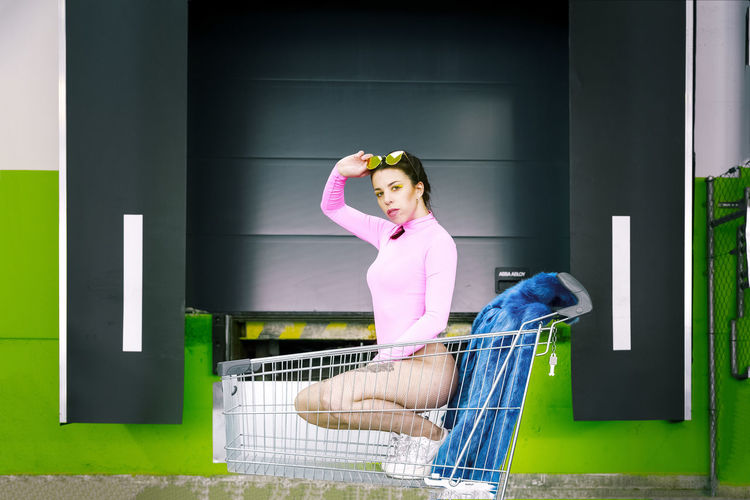 Portrait of sensuous woman crouching in shopping cart