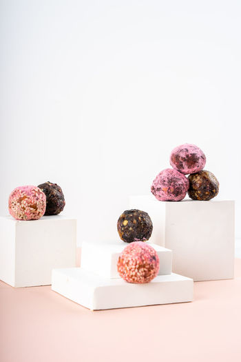 Homemade pink matcha energy balls in a podium display, pedestal. vegeterian diet sweet brain food. 