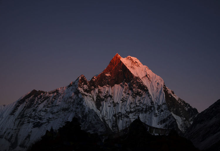 Low angle view of snowcapped mountain against sky at twilight