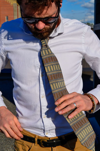 Close-up of man wearing necktie while standing outdoors
