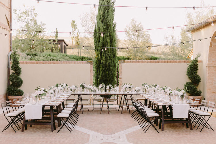 Empty chairs and tables against plants