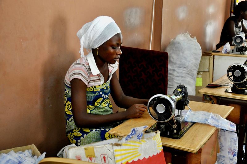 Woman using sewing machine working in workshop