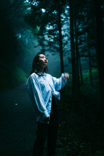 Young woman looking up in forest