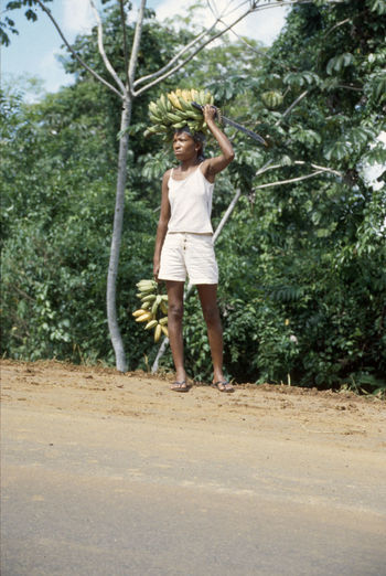 Full length of woman standing on tree trunk