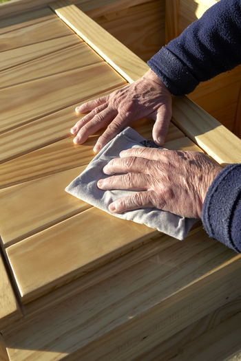 High angle view of person hand on wooden floor