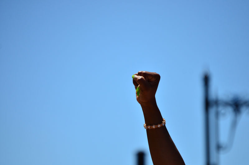Low angle view of human hand against clear sky