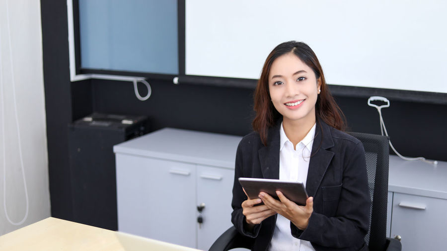 Portrait of businesswoman using laptop while sitting on table