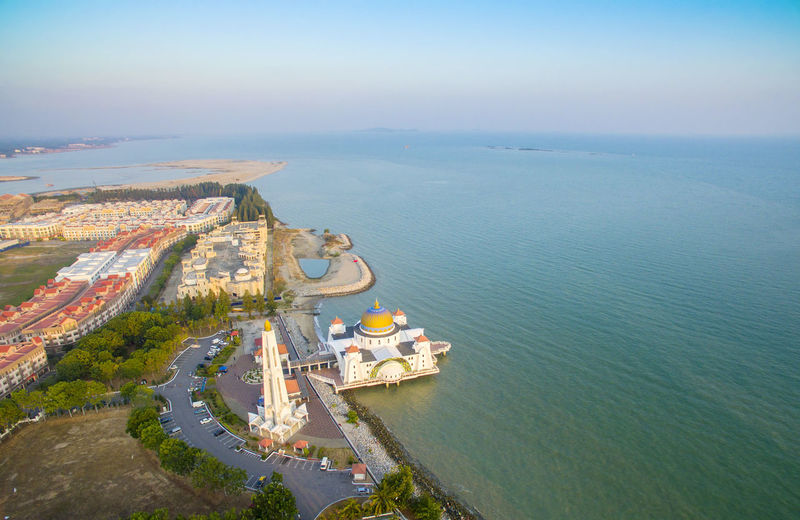 Aerial view of malacca straits mosque by blue sea against sky