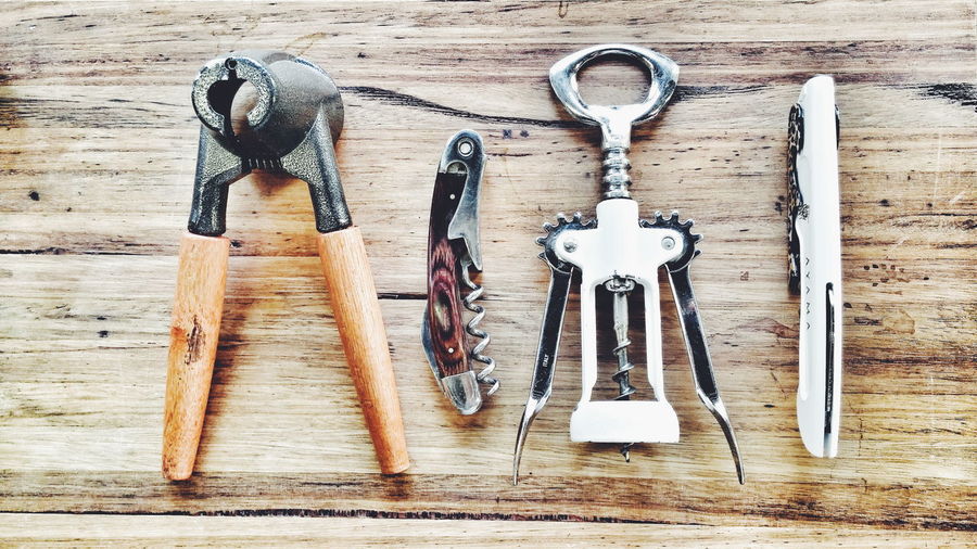 High angle view of bottle opener tools on wooden table