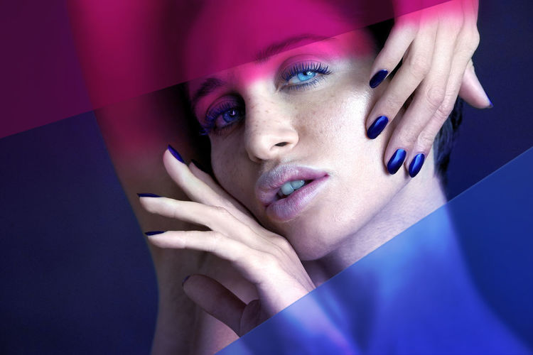 Portrait of woman against blue and pink background