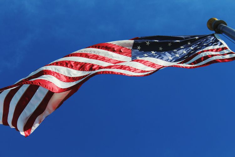 Directly below shot of american flag waving against sky