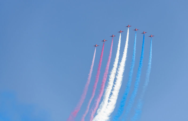 Low angle view of airshow against blue sky