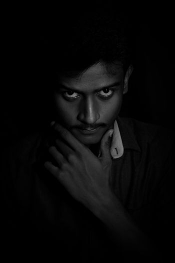 Portrait of young stylish man in darkroom. stylish man black and white.