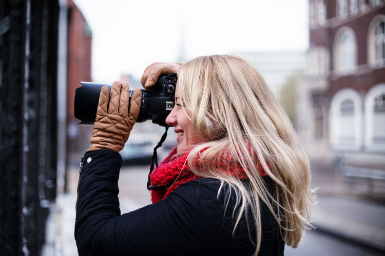Portrait of a blonde woman photographing