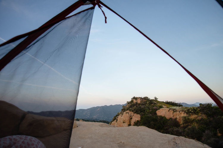 Mountains against sky seen through tent during sunset