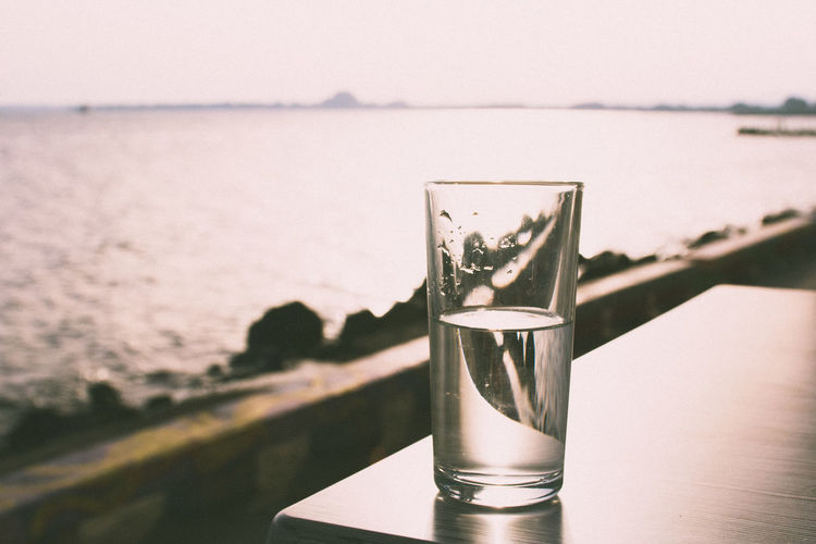 Glass of water on table against sea at pomorie