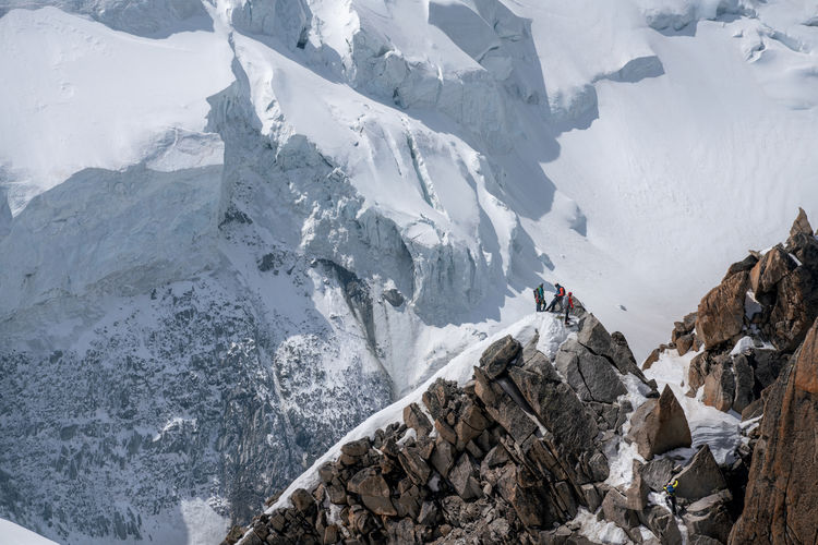 High angle view of people standing on snowcapped mountain