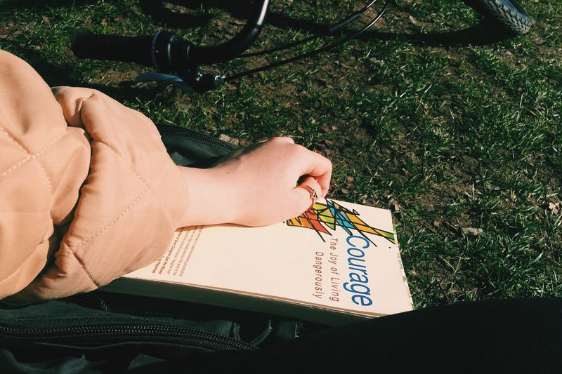 Cropped image of person with book at park