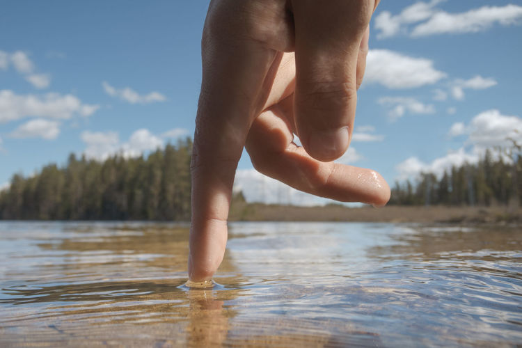Close-up of hand touching water