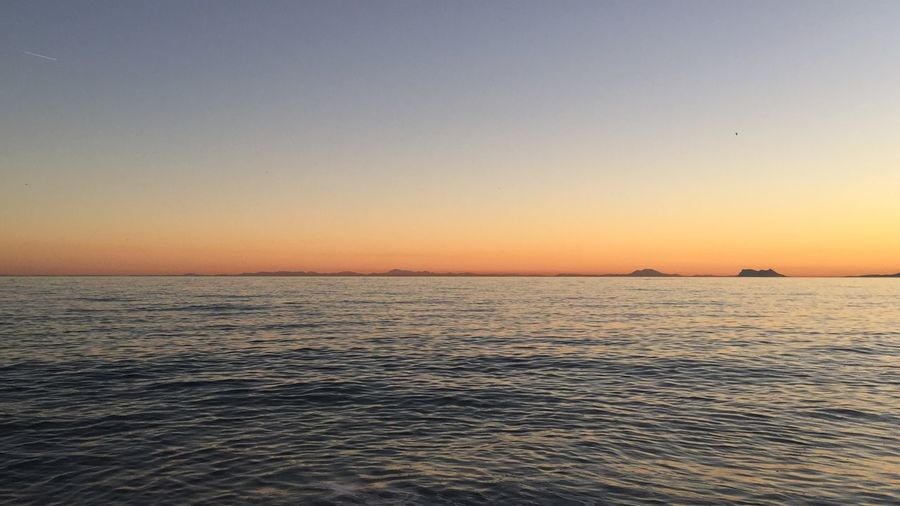 Scenic view of sea against clear sky during sunset