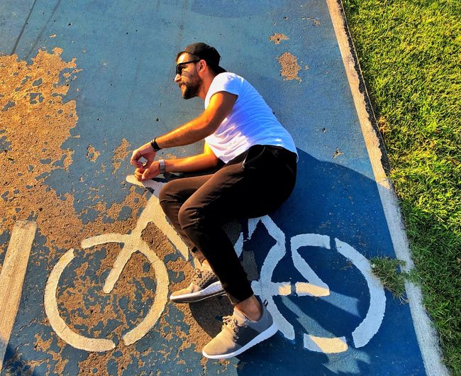 High angle view of man lying on road with bicycle symbol