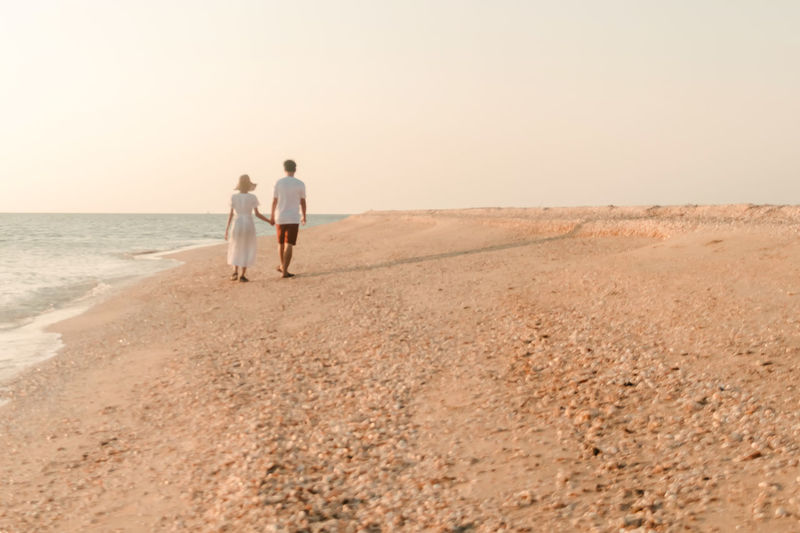 The couple are happily strolling on the beach both of which promise to forever love each other.