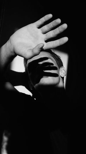 Close-up of woman with hand on black background