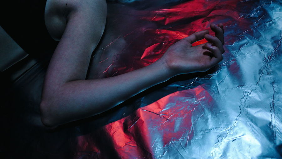 Cropped image of woman lying on foil paper