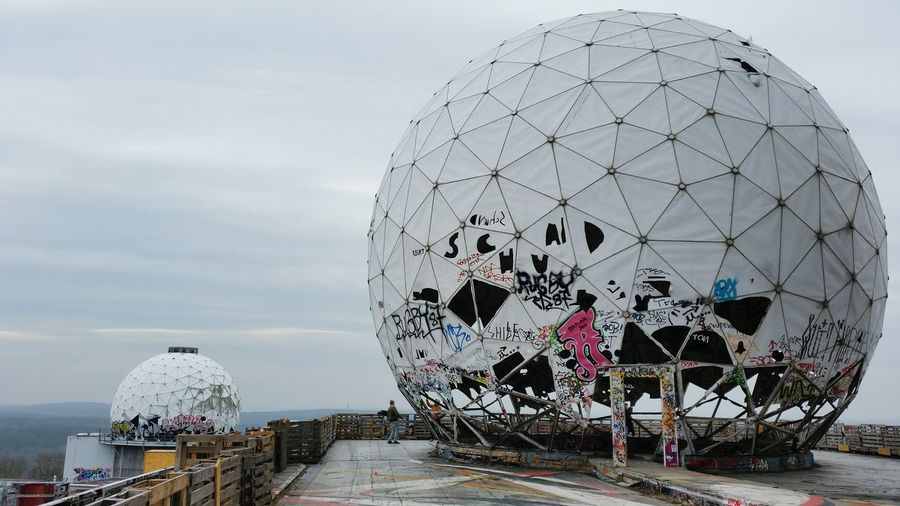 Graffiti on abandoned radar dome against sky