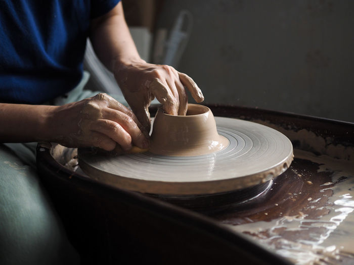 Woman starts to create a ceramic cup on the pottery wheel. working with clay on potter's wheel.