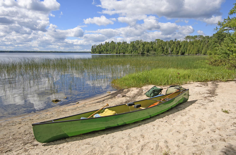 Loading the canoe on the shore of basswood lake in quetico provincila park in ontario
