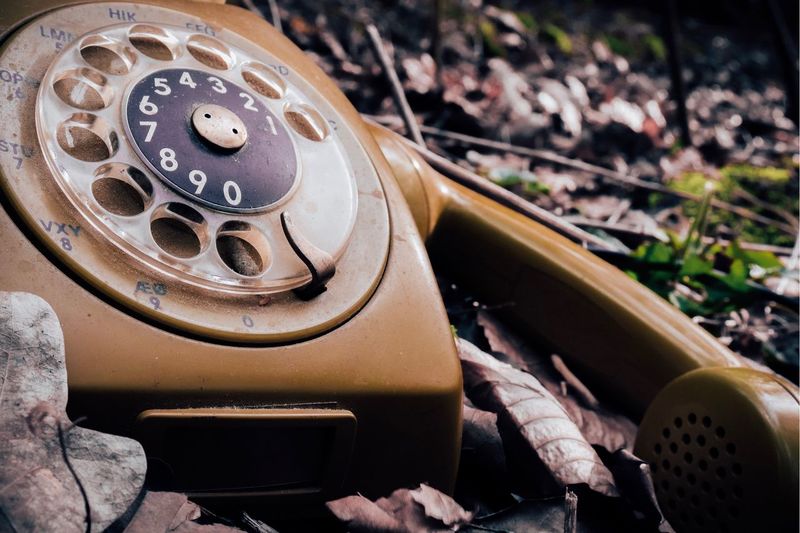 Close-up of old rotary phone on land