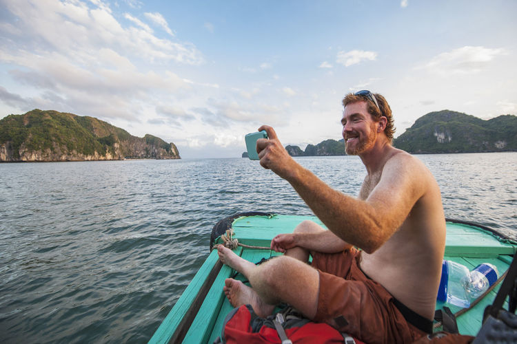 Man taking selfie on a boat at halong bay in vietnam