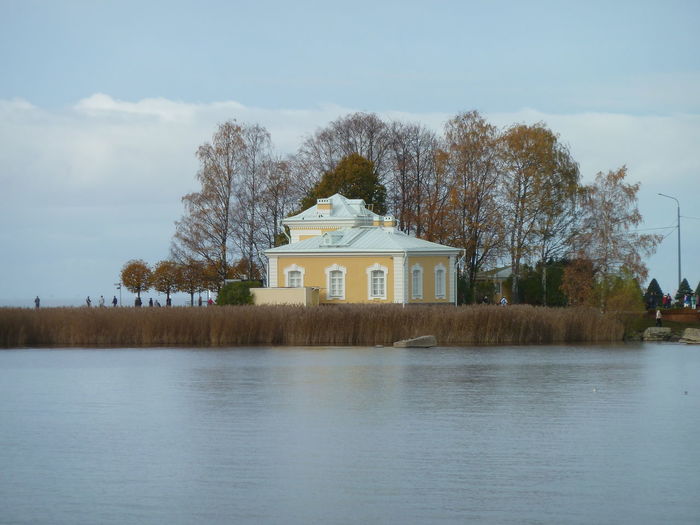 Building by lake against sky