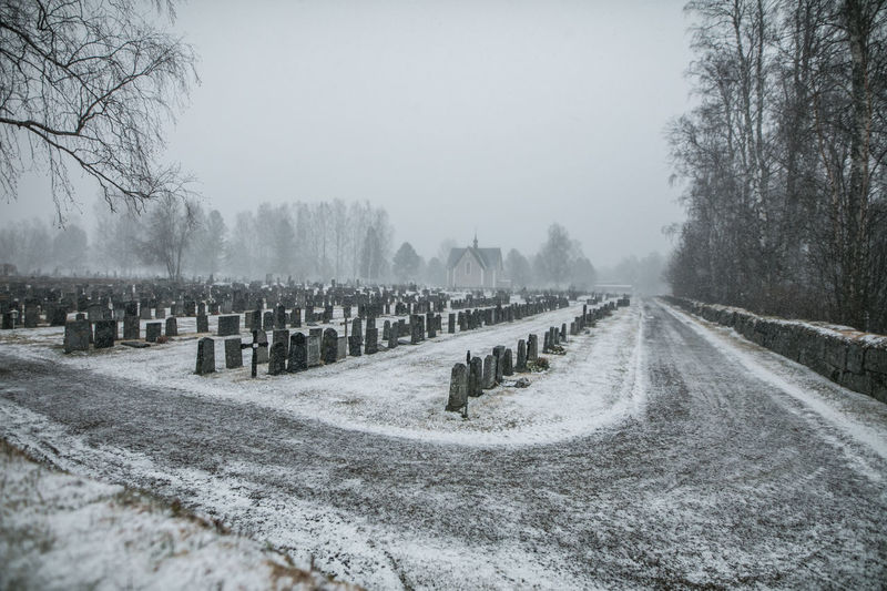 Cemetery against sky during winter