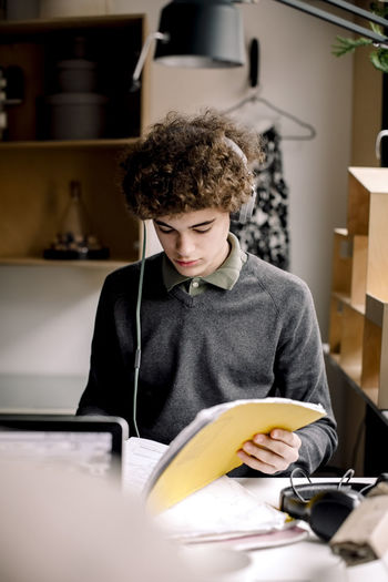Boy wearing headphones while studying at home
