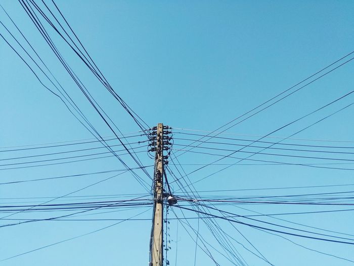 Low angle view of power line against clear blue sky