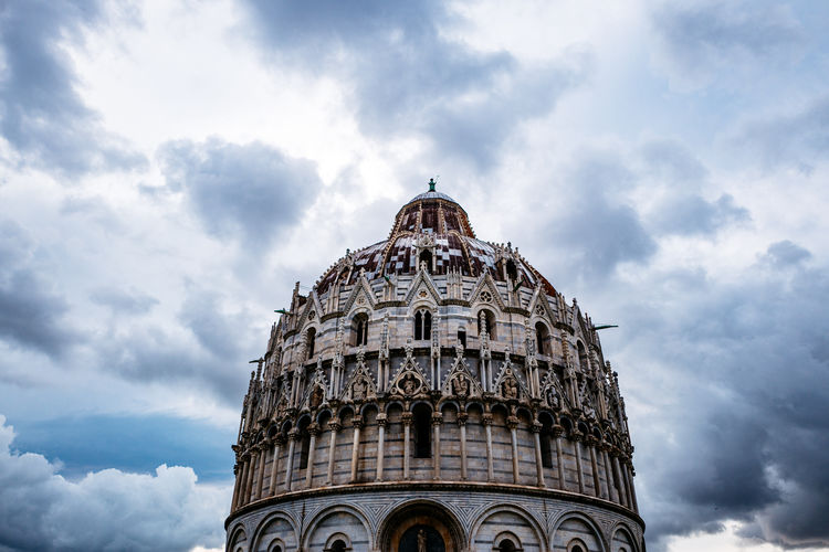 Low angle view of pisa baptistery against cloudy sky
