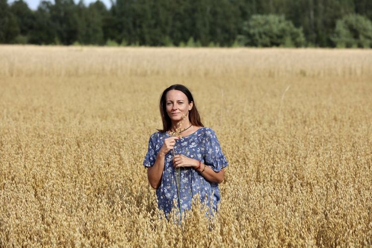 Portrait of young woman standing in field