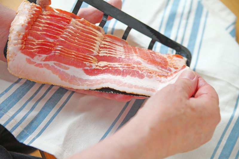Older man with sliced bacon package