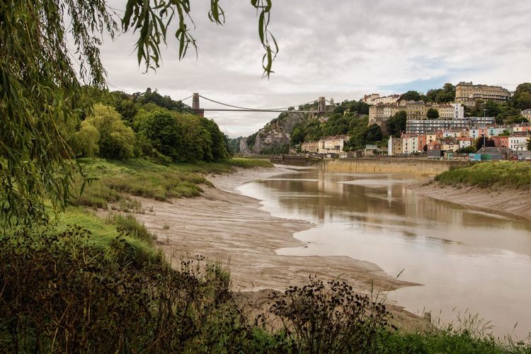 River by buildings in town against sky