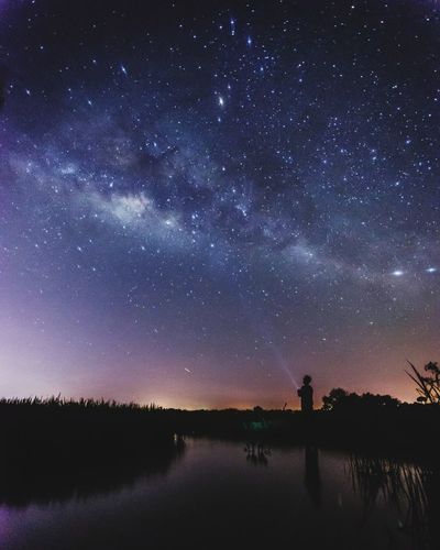 Scenic view of lake against sky at night