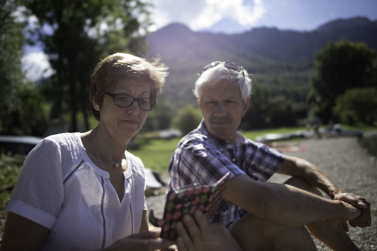 Senior couple using mobile phone outdoors