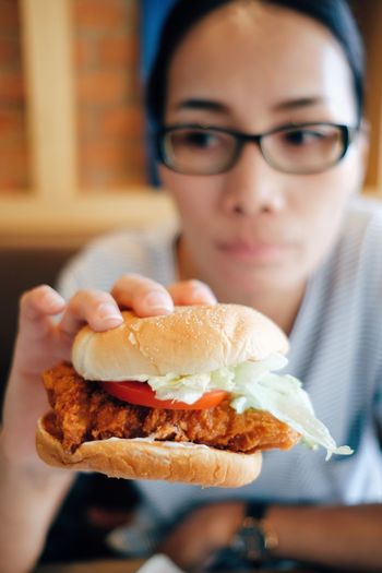 Young woman eating chicken burger
