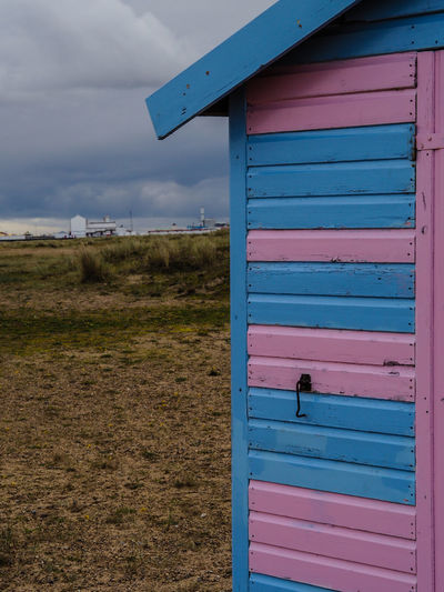 View of beach hut on field against sky